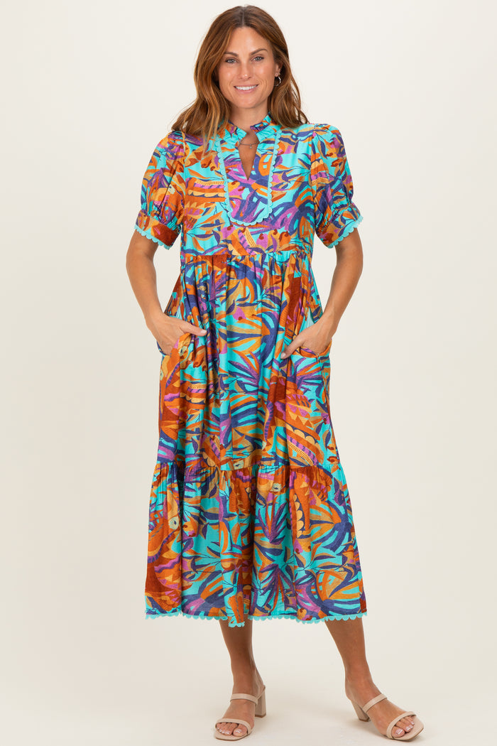 woman wearing a colorful floral print midi dress with short sleeves and pockets