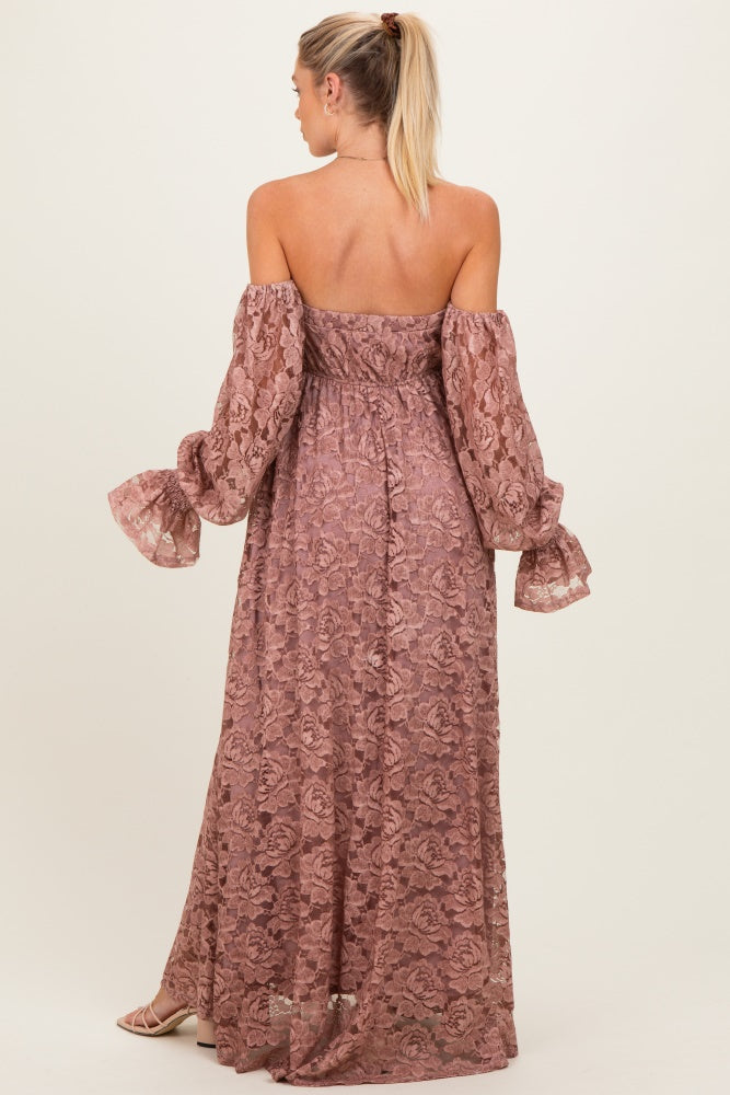 woman wearing a mauve off-the-shoulder lace maternity dress with long puff sleeves and a flowing skirt