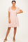 woman wearing a pink lace short dress with flutter sleeves and a fitted waist, paired with nude heels