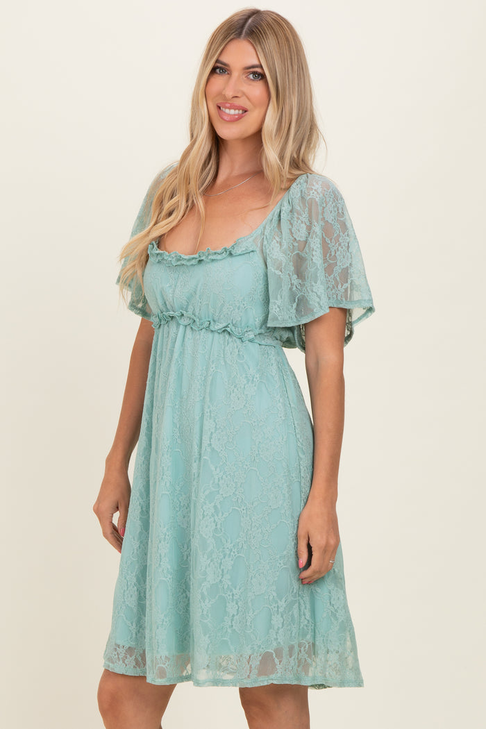 woman wearing a mint green lace short dress with flutter sleeves and a smocked waist