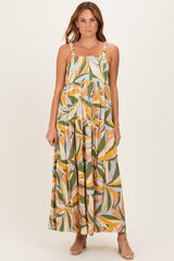 woman wearing a colorful floral print maxi dress with adjustable straps and a tiered design