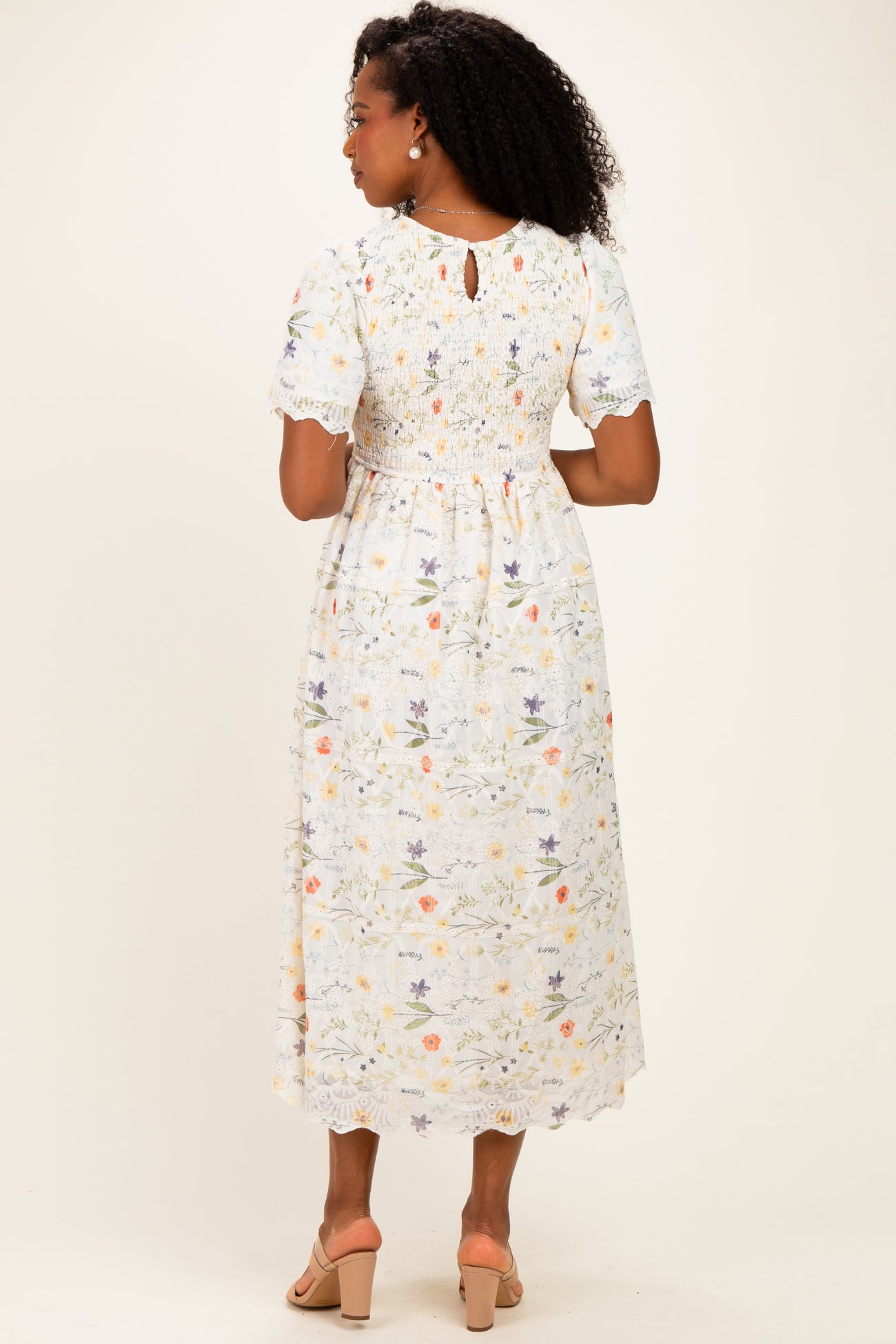 woman wearing a floral midi dress with short sleeves and a keyhole detail at the back