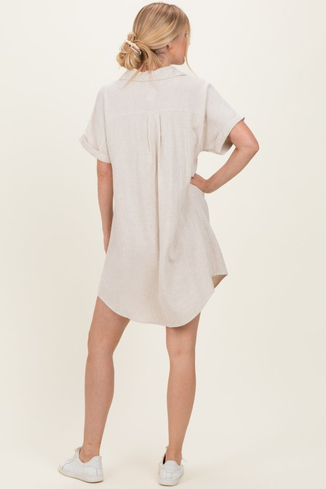 woman wearing a short sleeve beige linen shirt dress with a relaxed fit and rolled sleeves, seen from the back