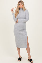 woman wearing a grey ribbed midi dress with a high neckline and side slit, styled with black slide sandals