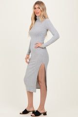 woman wearing a grey ribbed long sleeve midi dress with a side slit and high neckline