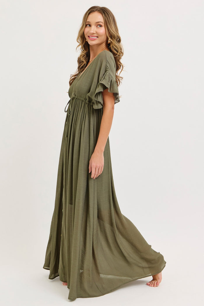 woman wearing a long olive green maxi dress with short ruffle sleeves and a cinched waist