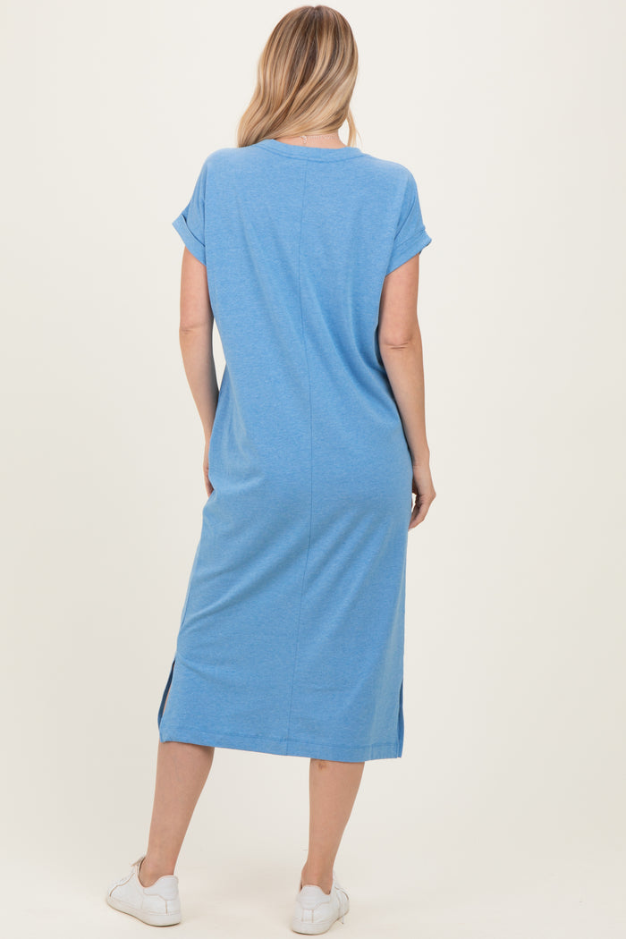 woman wearing a casual blue short sleeve midi dress with side slits and white sneakers