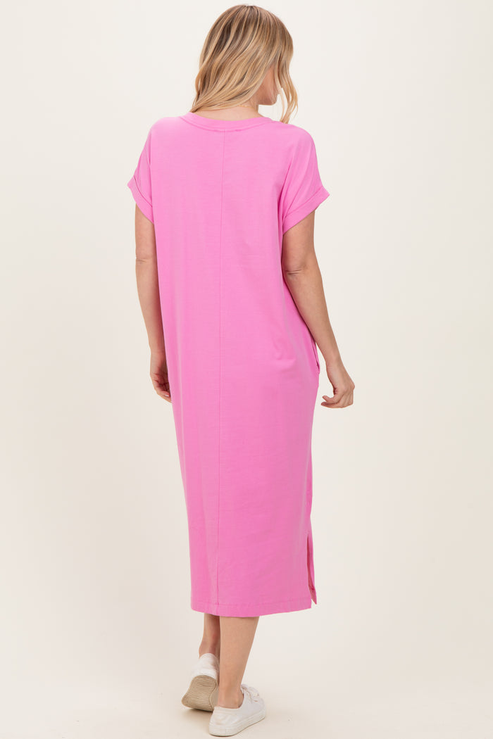 woman wearing a long pink casual dress with short sleeves and side slits, shown from the back