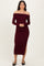 woman wearing a burgundy off-the-shoulder bodycon midi dress with side slit and long sleeves