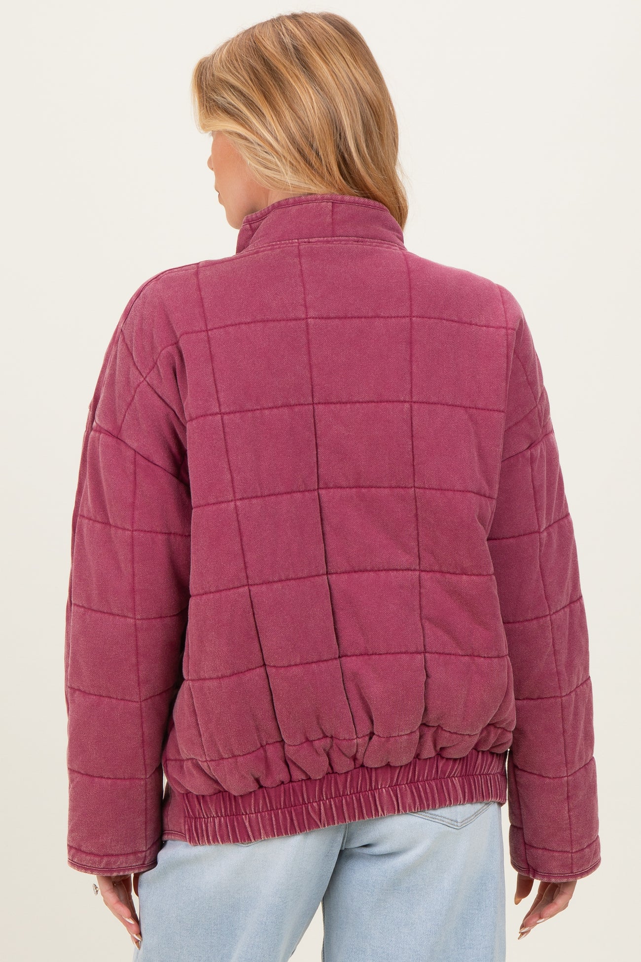woman wearing a burgundy quilted maternity jacket with a cinched waist, shown from the back