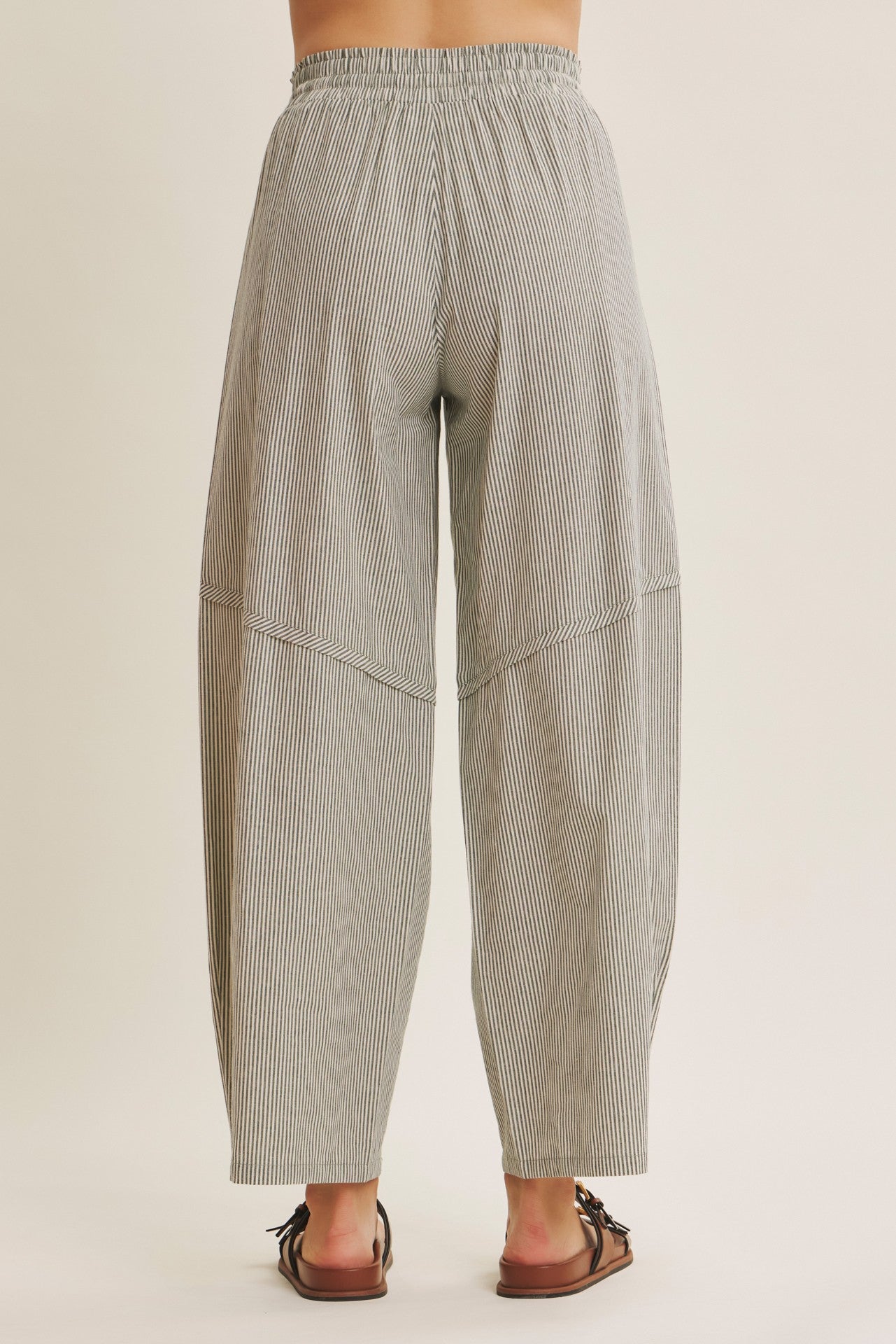 woman wearing gray and white striped wide leg pants with an elastic waistband, view of the back