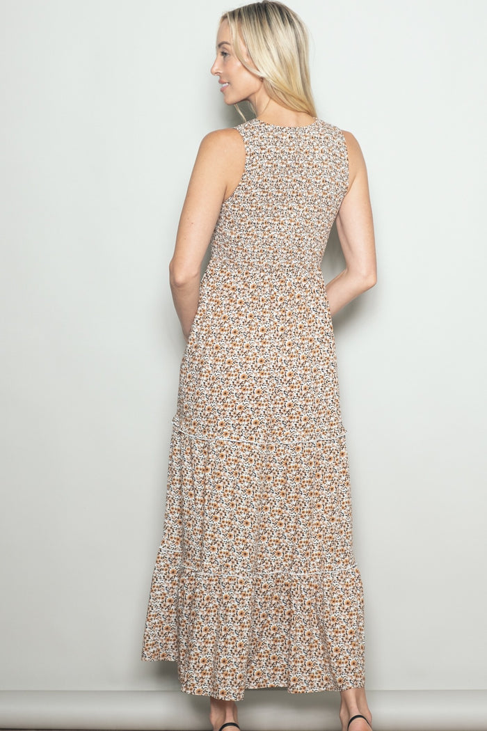woman wearing a back view of a floral print sleeveless maxi dress with tiered ruffles