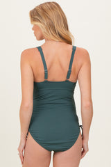 woman wearing a dark green ribbed maternity swimsuit with adjustable straps, shown from the back
