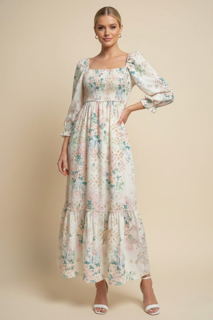 woman wearing a long floral print maxi dress with puff sleeves and a tiered skirt