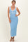 woman wearing a light blue sleeveless maxi dress with white trim and a tie detail at the bust