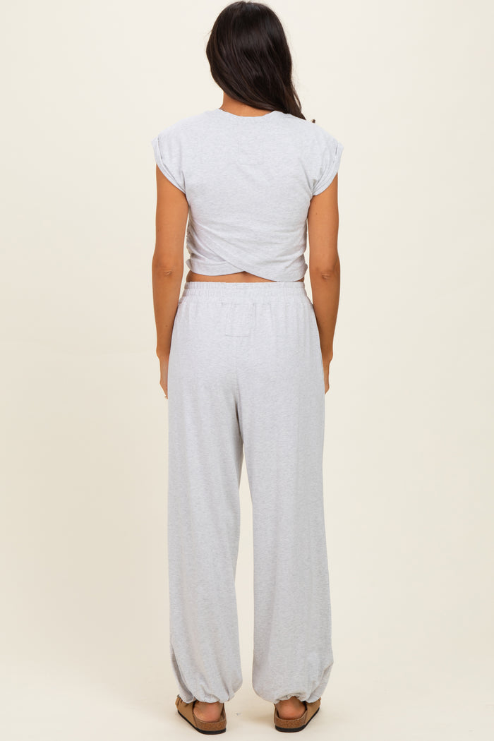 woman wearing a gray cropped t-shirt and relaxed fit gray sweatpants, viewed from the back