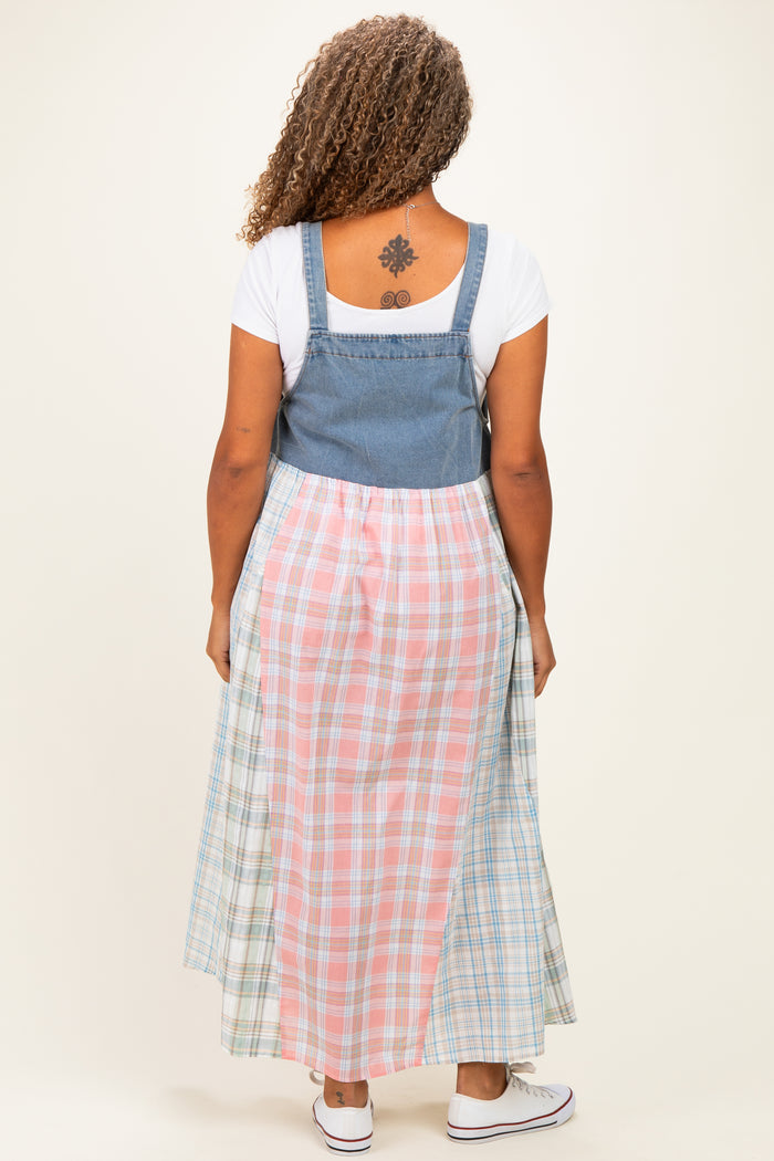 woman wearing a plus-size denim and plaid maxi dress with a fitted top and flowing skirt seen from the back