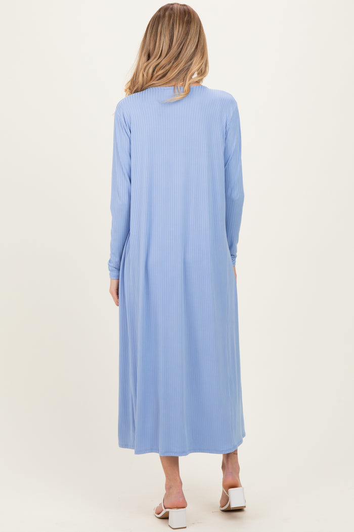 woman wearing a light blue long sleeve maternity maxi dress, shown from the back with a flowing silhouette