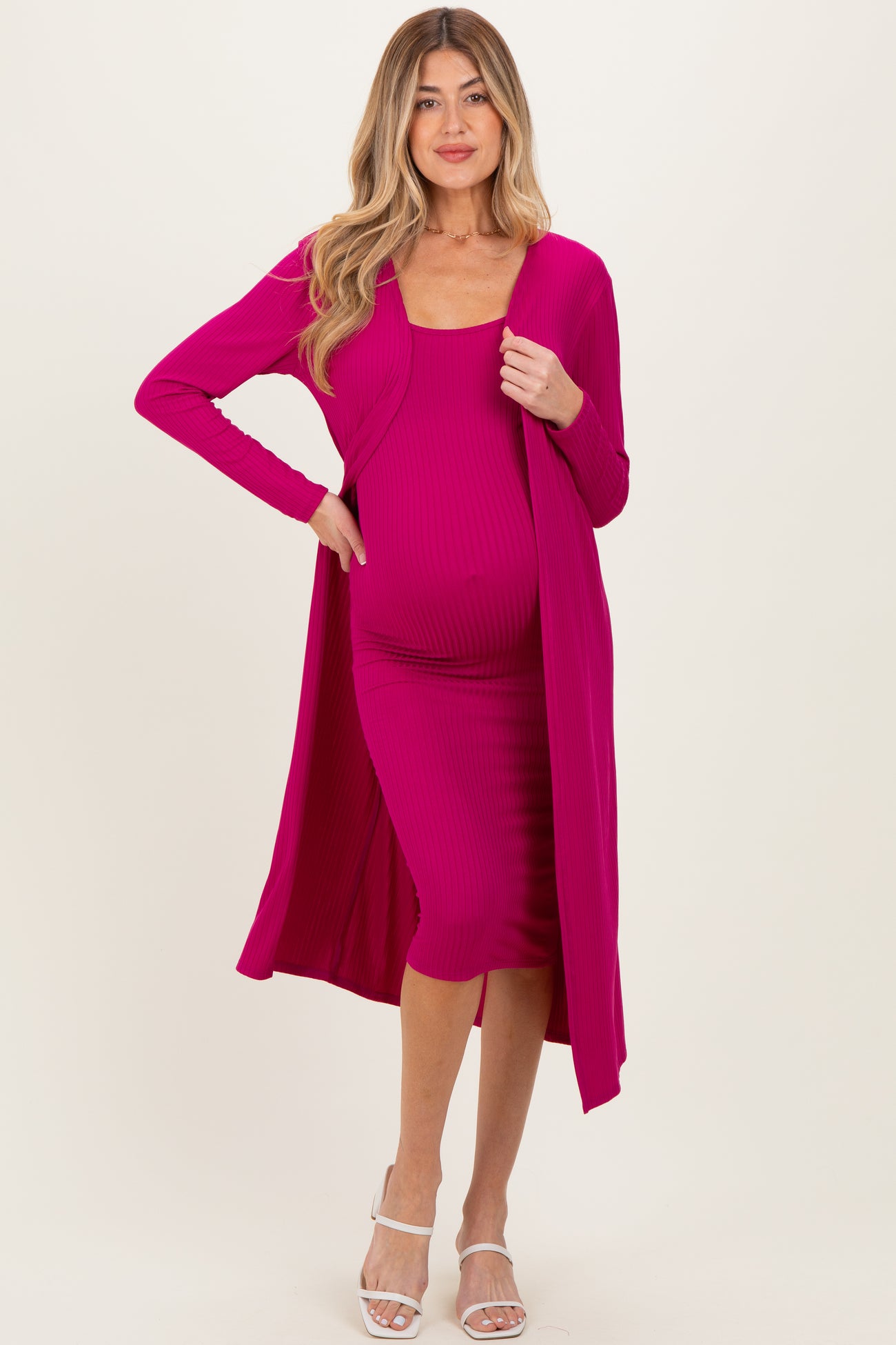 woman wearing a hot pink maternity dress with a matching long cardigan and visible baby bump