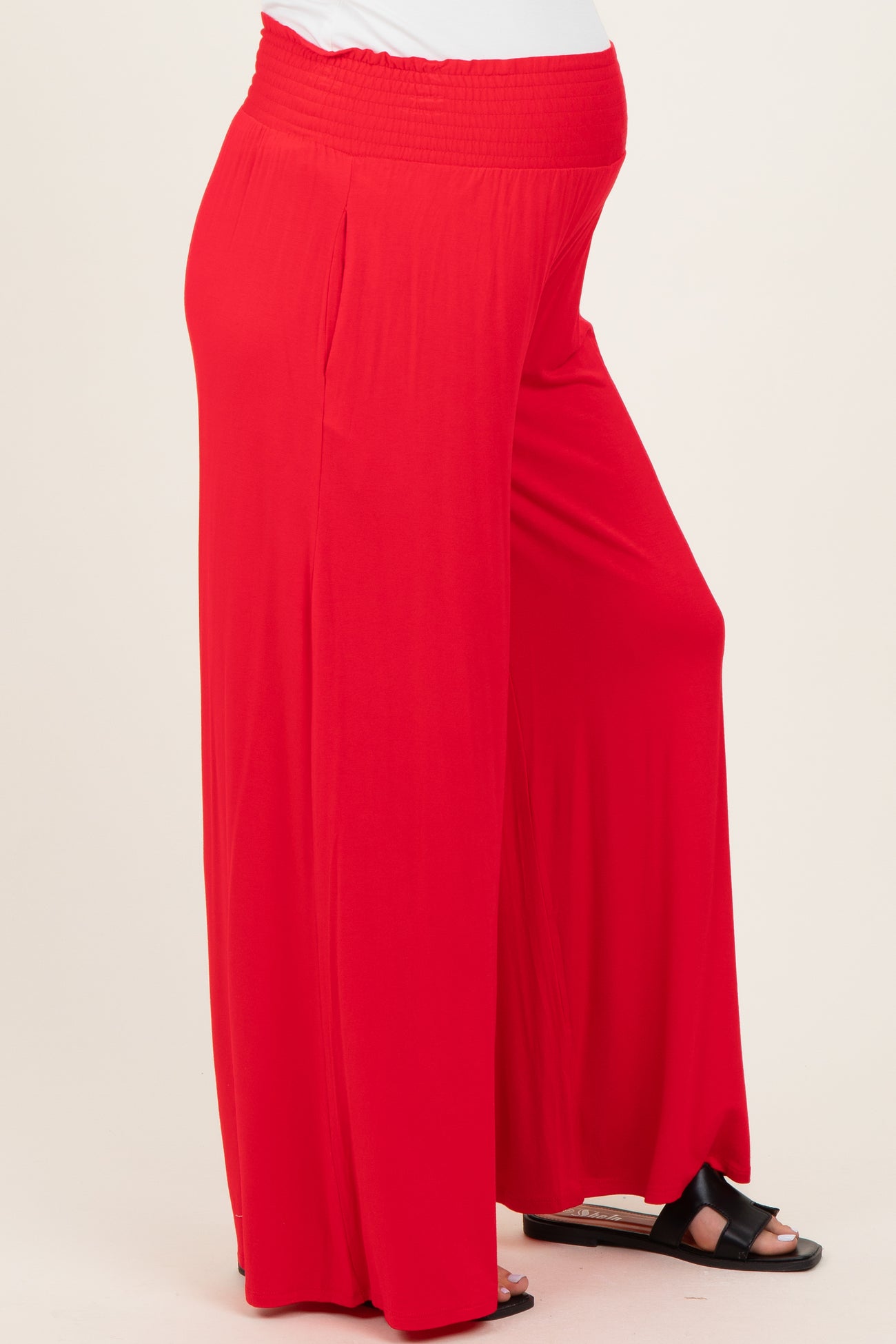 woman wearing a flowing red maternity maxi skirt with an elastic waistband and a visible baby bump