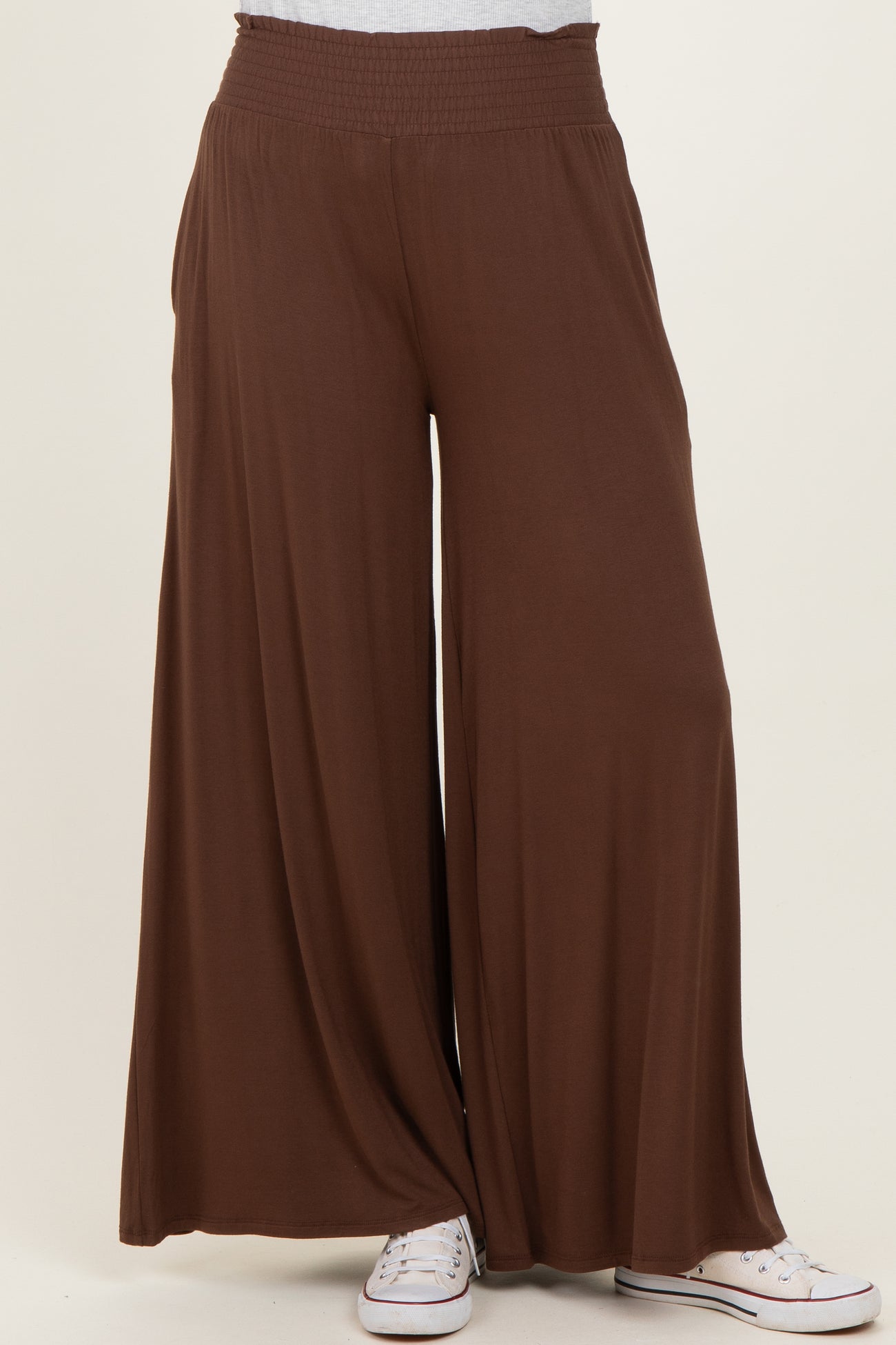 wide leg brown palazzo pants with a smocked waistband, styled with white sneakers