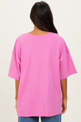 woman wearing a loose-fitting bright pink oversized t-shirt from the back