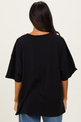 woman wearing a loose-fitting black oversized t-shirt seen from the back, paired with blue jeans