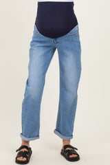 woman wearing light blue maternity jeans with a navy high waistband and rolled cuffs, styled with black sandals