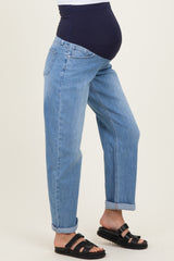 woman wearing light blue maternity jeans with a dark blue belly panel and rolled cuffs, showcasing a visible baby bump
