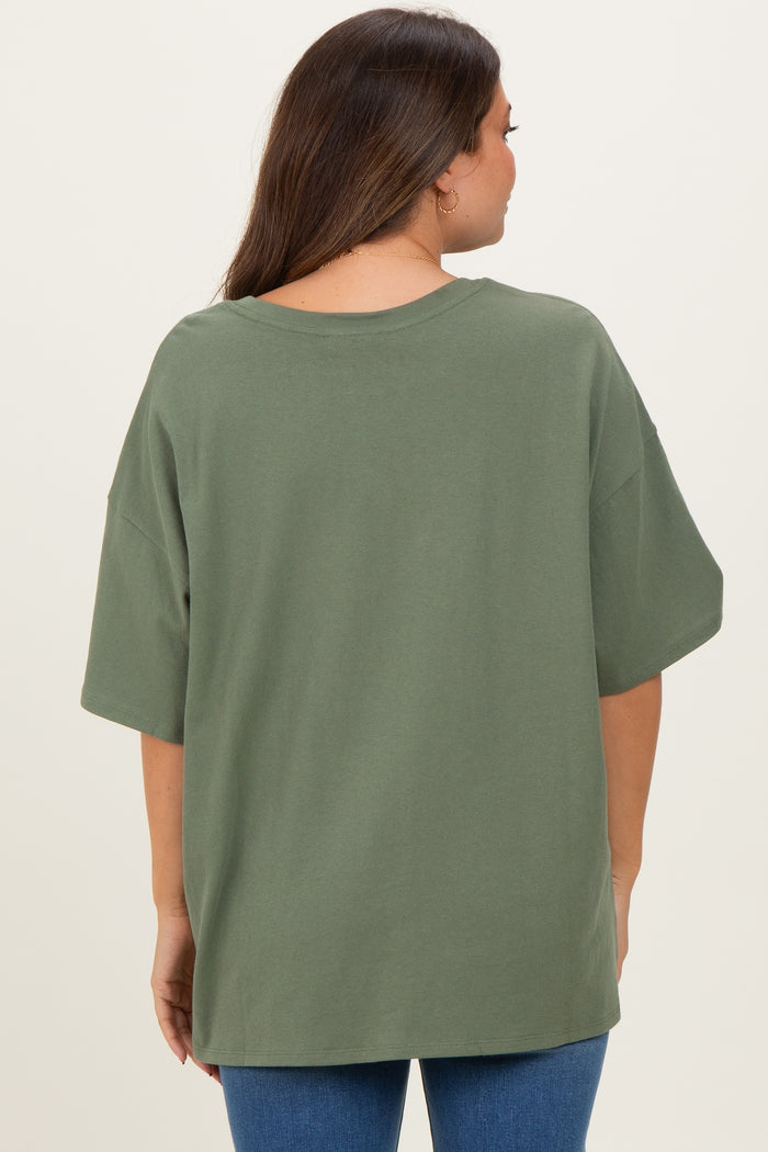 woman wearing an olive green oversized maternity t-shirt from the back, paired with blue jeans