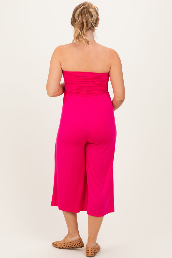 woman wearing a bright pink strapless maternity jumpsuit, shown from the back