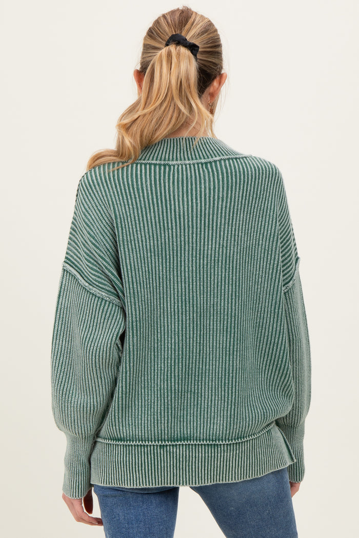 woman wearing a green ribbed oversized maternity sweater with a relaxed fit and long sleeves