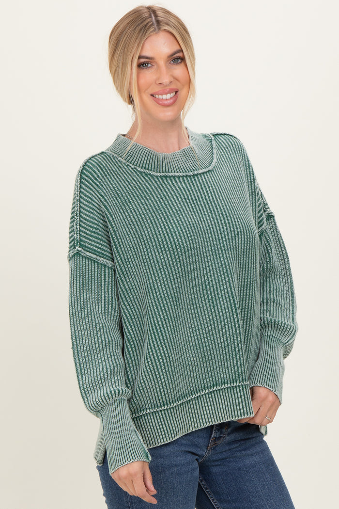woman wearing a green striped oversized sweater and blue jeans