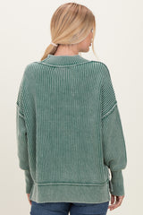 woman wearing a green striped oversized sweater with long sleeves and a relaxed fit, viewed from the back