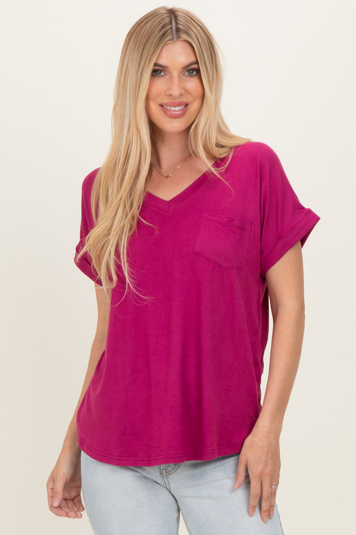 woman wearing a fuchsia v-neck t-shirt with roll sleeves and a chest pocket, posing against a neutral background