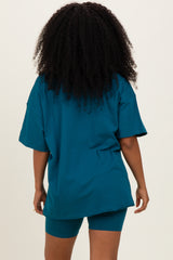 woman wearing a teal oversized t-shirt and matching bike shorts, viewed from the back