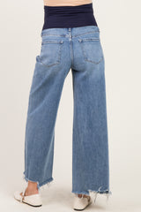 woman wearing light blue wide-leg maternity jeans with a frayed hem, showing the back view