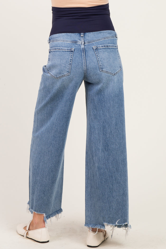 woman wearing light blue wide-leg maternity jeans with a frayed hem, showing the back view