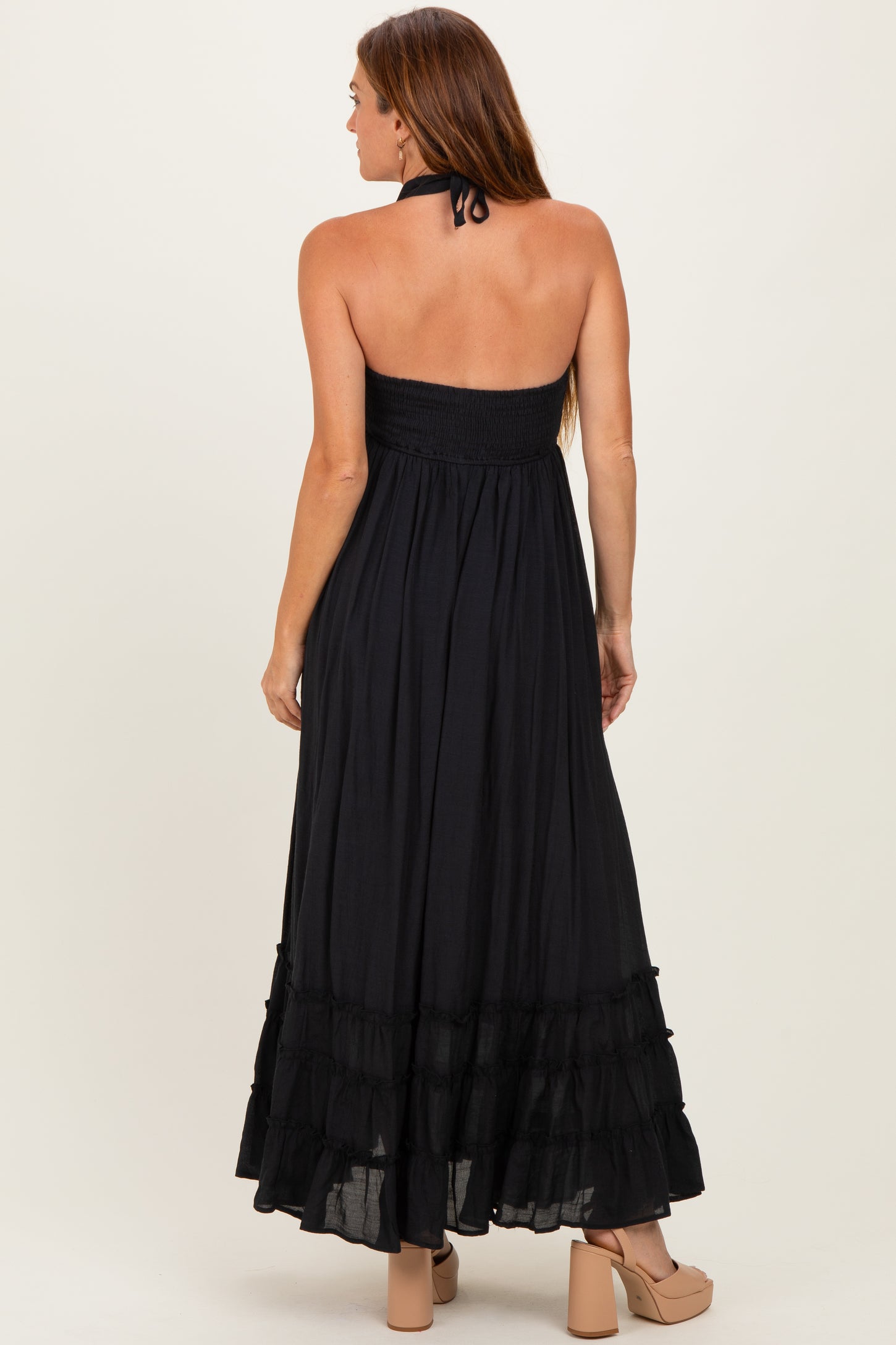 woman wearing a black strapless maxi dress with a smocked bodice and ruffle hem