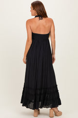 woman wearing a black strapless maxi dress with a smocked bodice and ruffle hem