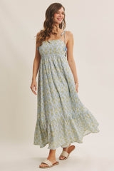 woman wearing a light blue floral maxi dress with spaghetti straps and a tiered skirt