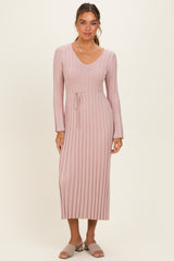 woman wearing a light pink ribbed long sleeve dress with a v-neck and a tie waist detail