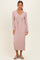woman wearing a light pink ribbed long sleeve dress with a v-neck and a tie waist detail