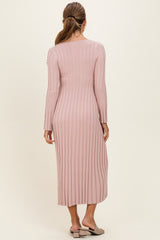 woman wearing a pink ribbed long sleeve midi dress, viewed from the back
