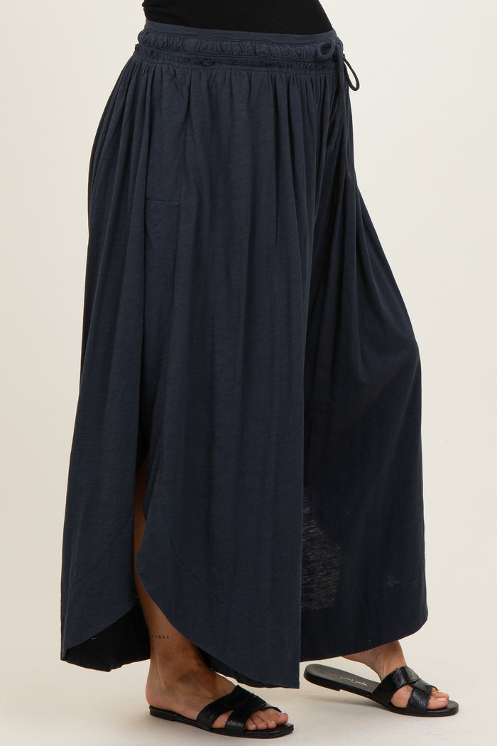 woman wearing a navy blue maternity maxi skirt with a high-low hem and elastic waistband