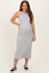 woman wearing a gray sleeveless maternity dress that hugs her baby bump, paired with black sneakers