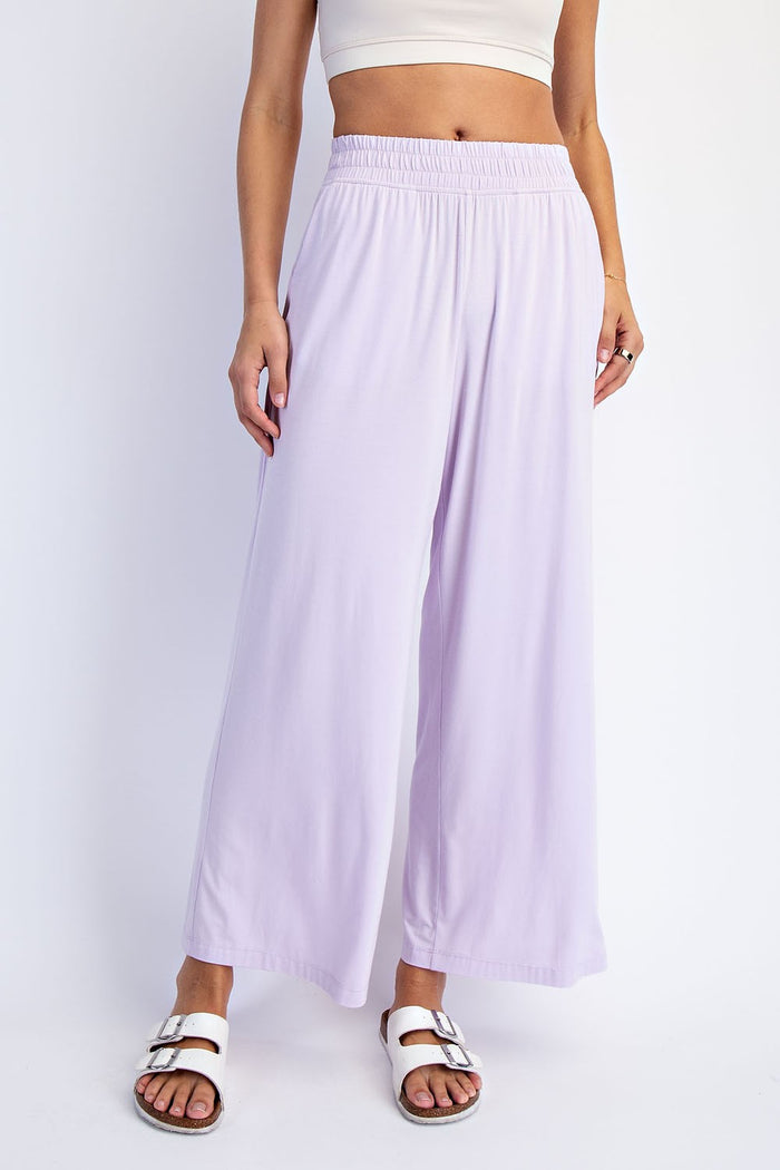 woman wearing lilac wide-leg flowy pants with an elastic waistband and white sandals
