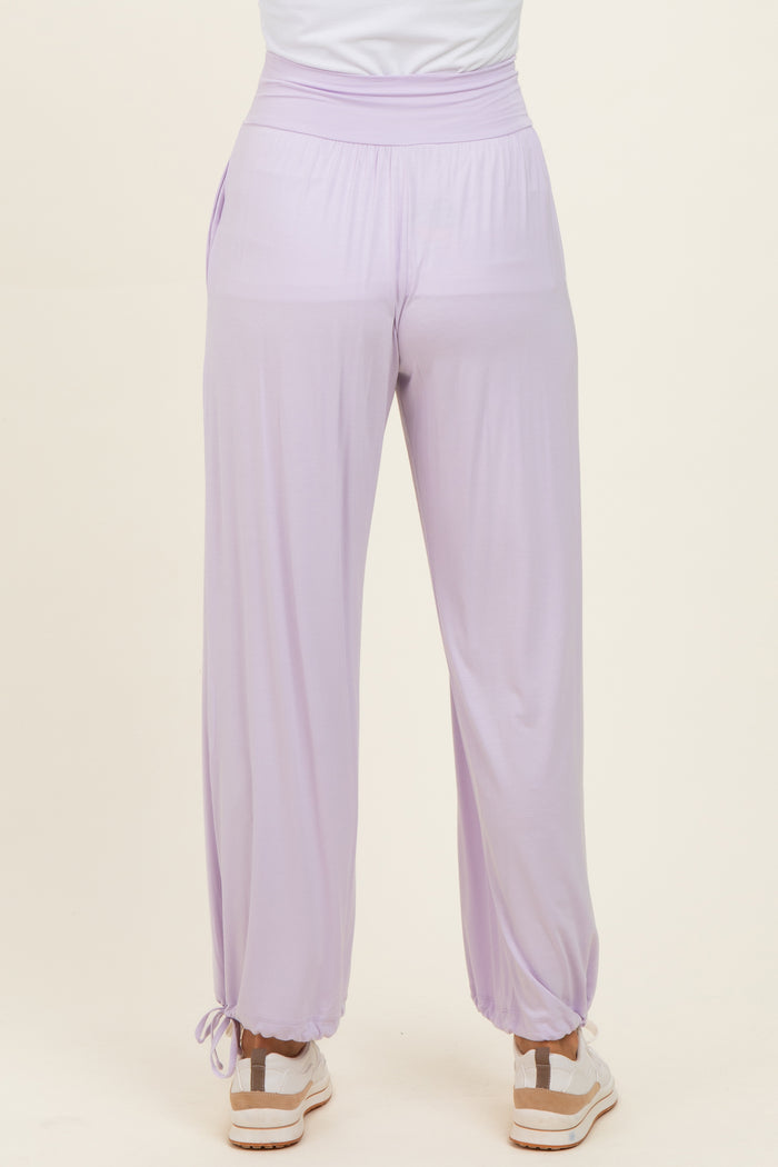 woman wearing lavender high-waisted lounge pants with elastic cuffs and drawstring detail at the ankles