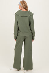 woman wearing a green ribbed maternity lounge set with wide-leg pants and an oversized collar pullover, showing her baby bump