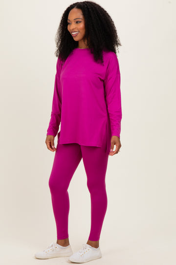 woman wearing a hot pink long sleeve top and matching leggings with side slits, styled with white sneakers